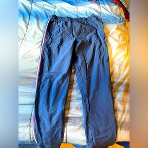 Rhone track pants, medium, navy blue with red and white stripe on the side